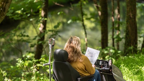 A female visitor uses a National Trust PMV to explore the accessible pathways at Woolacombe in Devon.